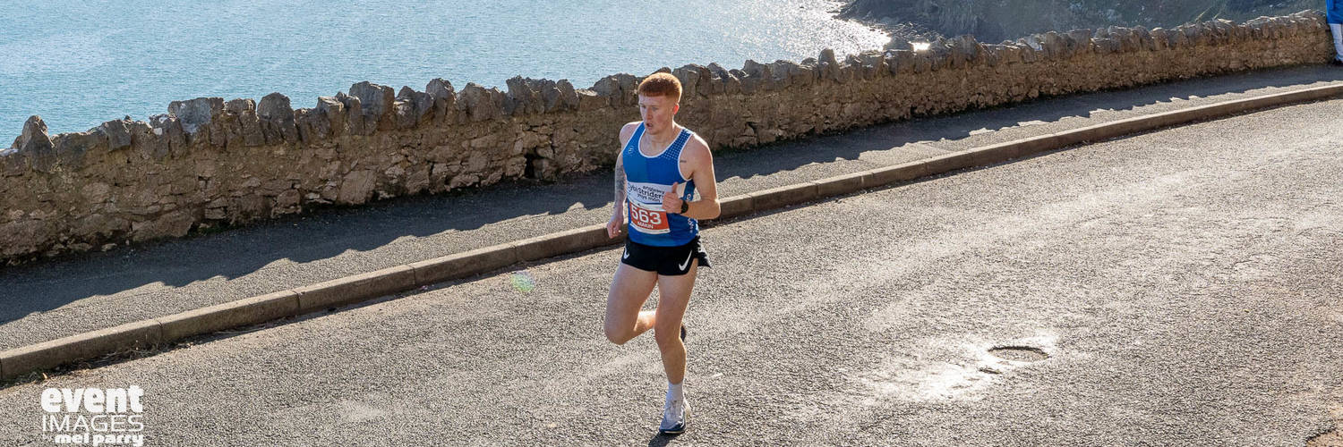 Runner in the Llandudno Nick Beer 10k with view of the pier