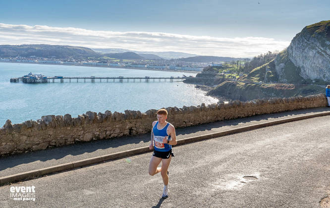 Runner in the Llandudno Nick Beer 10k with view of the pier