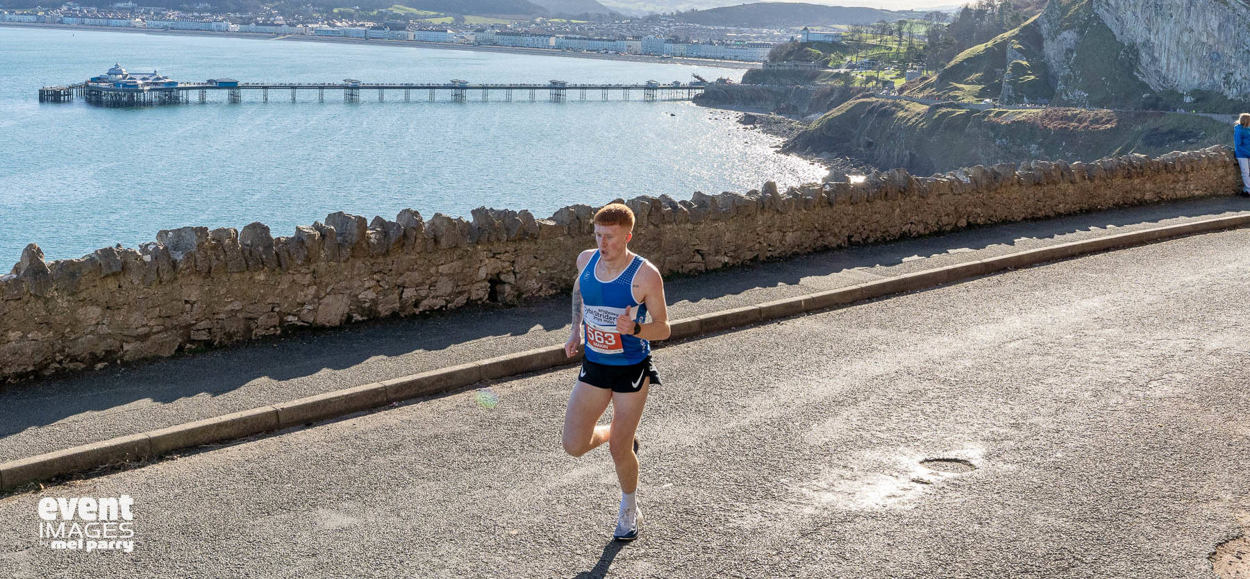 Runner in the Llandudno Nick Beer 10k with view of the pier