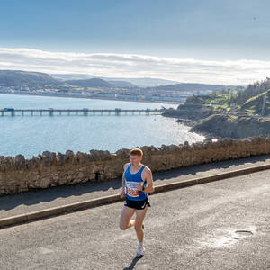 Runner in the Llandudno Nick Beer 10k with view of the pier