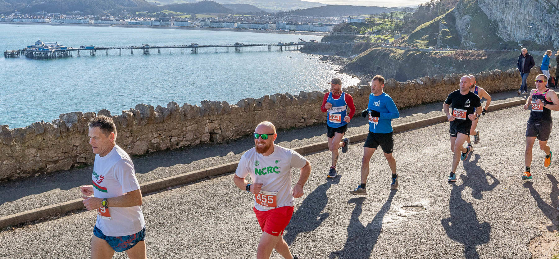 Runners on the Great Orme with Llandudno Pier in view